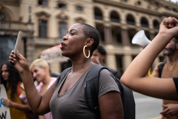 donna adulta di metà durante una manifestazione in strada - civil rights foto e immagini stock