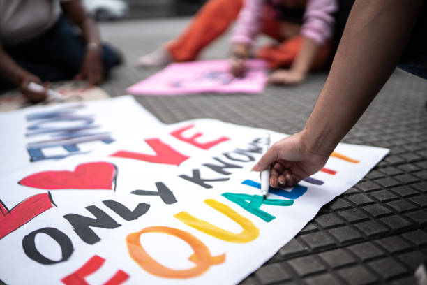 Woman's hands writing in posters before a protest in the street Woman's hands writing in posters before a protest in the street transgender protest stock pictures, royalty-free photos & images