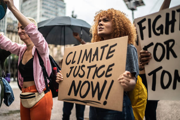 Protesters holding signs during a demonstration in the street Protesters holding signs during a demonstration in the street climate justice stock pictures, royalty-free photos & images