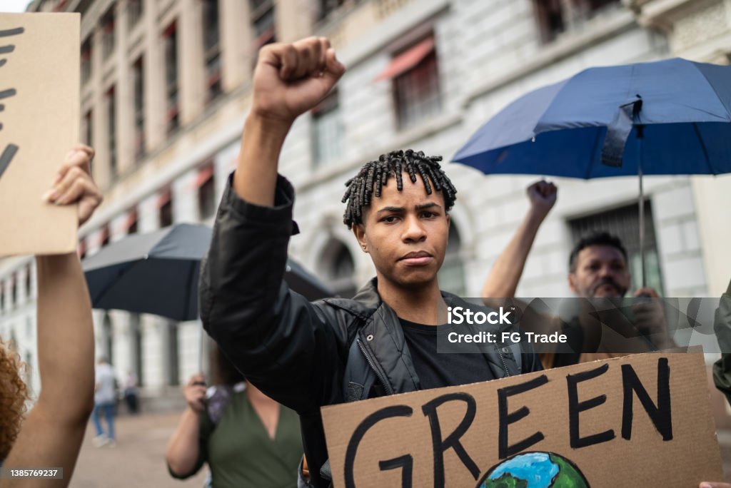 Young man holding a sign during a demonstration in the street Protest Stock Photo