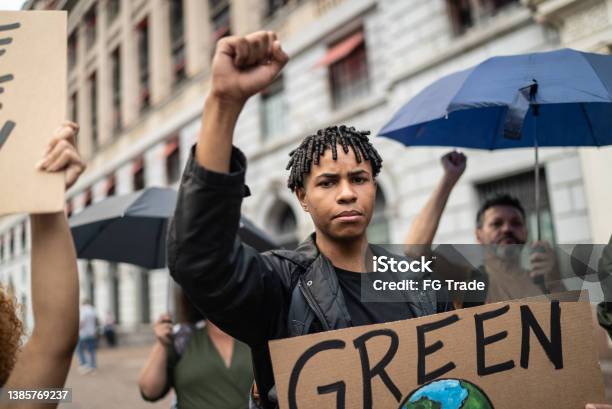 Young Man Holding A Sign During A Demonstration In The Street Stock Photo - Download Image Now