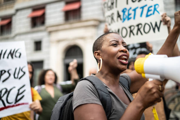 istock Mid adult woman leading a demonstration using a megaphone 1385769262