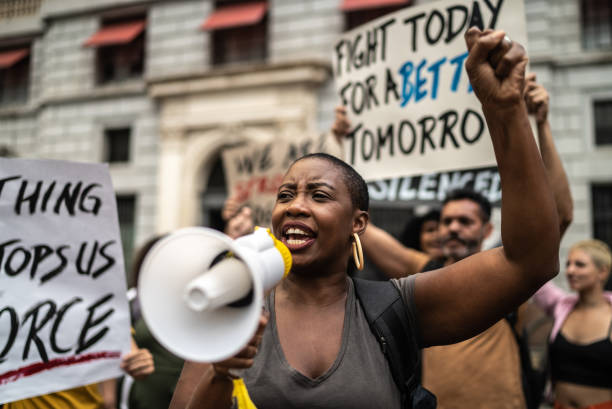istock Mid adult woman leading a demonstration using a megaphone 1385769268