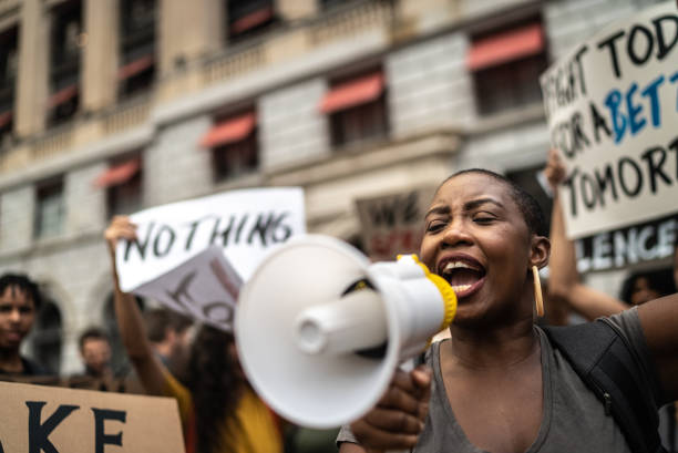 istock Mid adult woman leading a demonstration using a megaphone 1385769273
