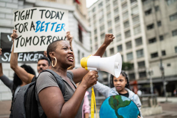 istock Mid adult woman leading a demonstration using a megaphone 1385769274