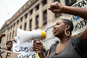 Mid adult woman leading a demonstration using a megaphone