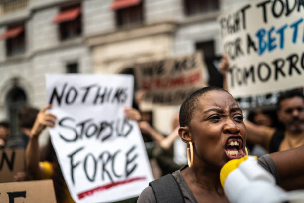 istock Mid adult woman leading a demonstration using a megaphone 1385769282