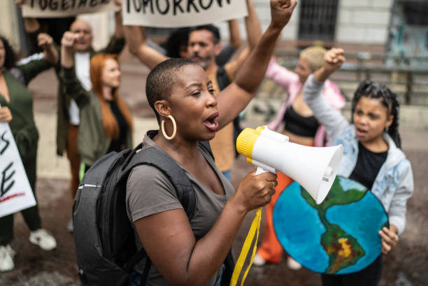 Mid adult woman leading a demonstration using a megaphone