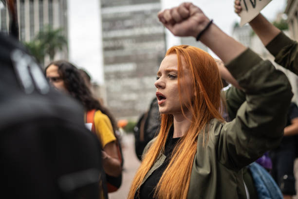 Young woman during a demonstration in the street Young woman during a demonstration in the street peace demonstration stock pictures, royalty-free photos & images