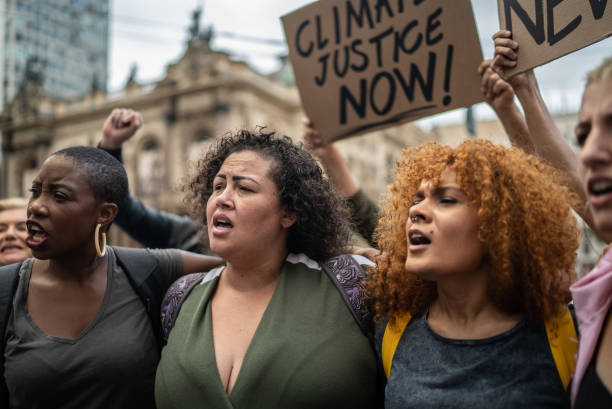 demonstranten während einer demonstration auf der straße - klimaschutz stock-fotos und bilder