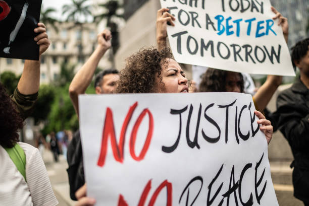 istock Protesters holding signs during a demonstration in the street 1385769357