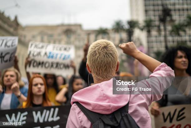 Young Woman Leading A Demonstration In The Street Stock Photo - Download Image Now - Protest, Generation Z, Rear View