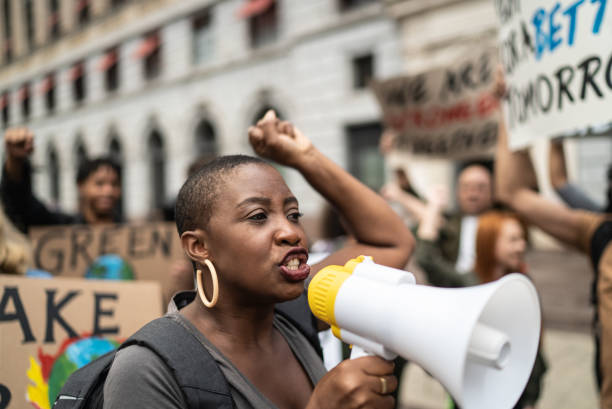 Mid adult woman leading a demonstration using a megaphone