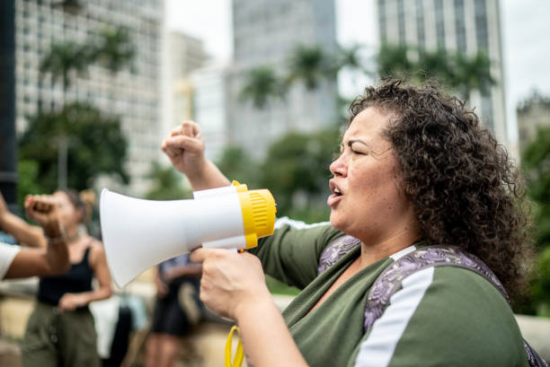 Woman leading protests on a demonstration for equal rights Woman leading protests on a demonstration for equal rights striker stock pictures, royalty-free photos & images