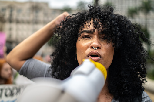 Portrait of a woman leading a demonstration using a megaphone