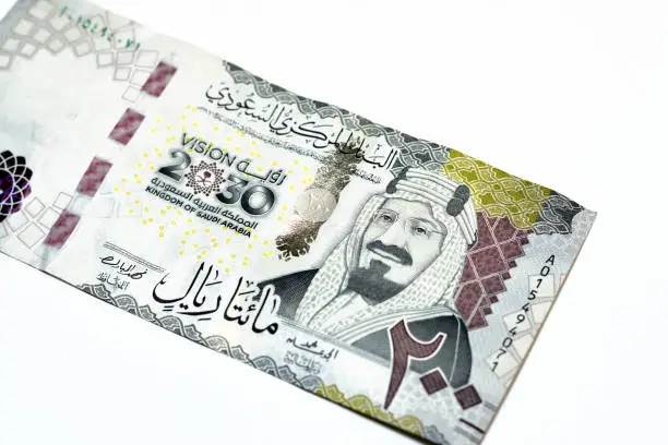 Obverse side of 200 two hundred Saudi riyals banknote features King Abdul Aziz Al Saud founder of the kingdom and a 3D logo of the nations vision 2030, Saudi Arabia money isolated on white background