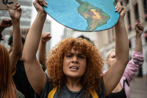demonstranten mit schildern während einer demonstration für umweltschutz - umweltschützer stock-fotos und bilder