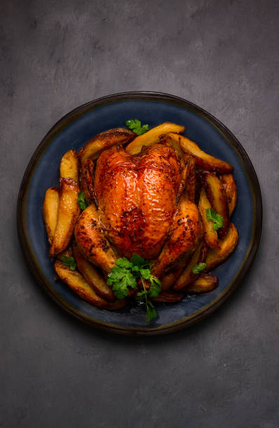 istock Fried whole chicken, with potatoes, on a gray background, no people. 1385783340