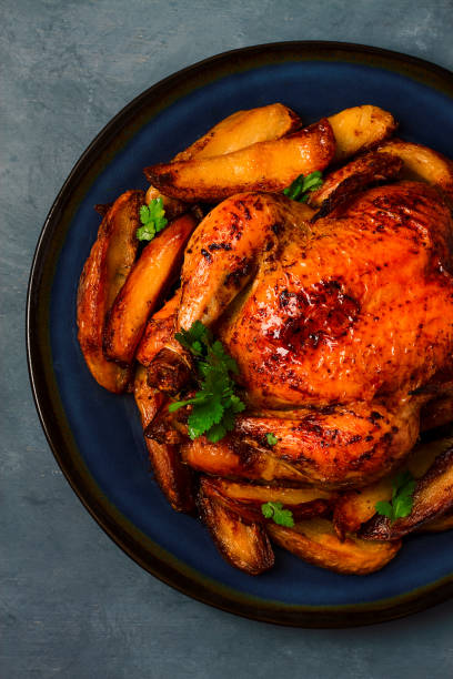 istock Fried whole chicken, with potatoes, on a gray background, no people. 1385783348