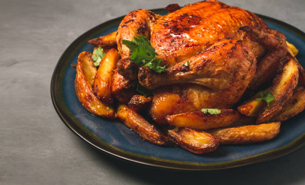 istock Fried whole chicken, with potatoes, on a gray background, no people. 1385783349