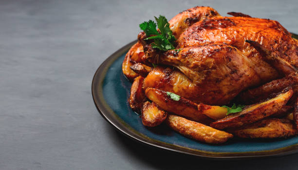 istock Fried whole chicken, with potatoes, on a gray background, no people. 1385783930