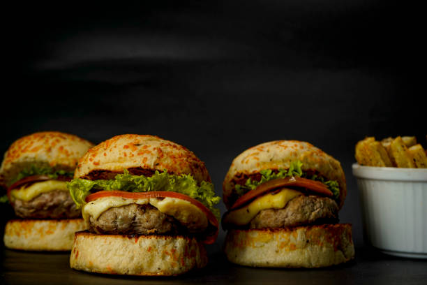 istock Three mini burgers on black background 1385786480