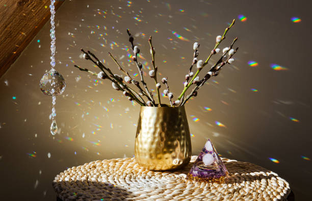 Selective focus on round ball shape crystal rainbow maker suncatcher hanging in home with Orgonite or Orgone pyramid. Good Feng Shui, Sha Chi reflection, energy flow concept.