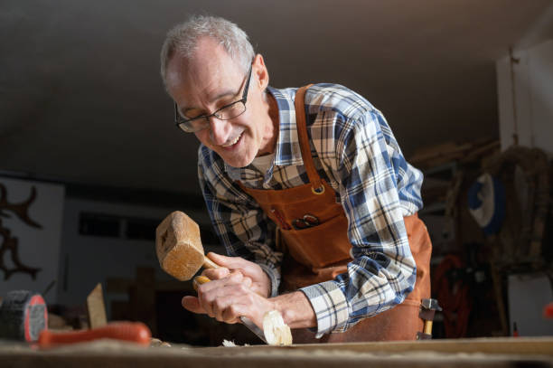 istock Close up of a Carpenter carving wood with chisel . 1385788846