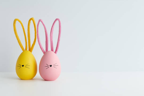 Pink and yellow Easter eggs with bunny faces, holiday decoration