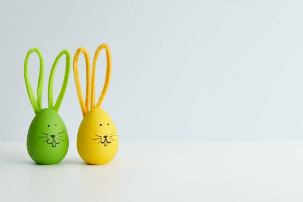 istock Green and yellow Easter eggs with bunny faces, holiday decoration 1385789790