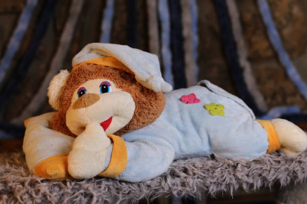 istock Sleepy teddy bear wearing classic pajamas 1385789814