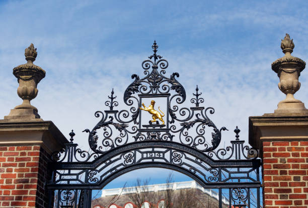 Cambridge, Massachusetts, USA - March 14, 2022: On the Charles River side of Winthrop House stands the Fly Club Gate (c. 1914). The panther symbol of the Fly Club is centered within the ironwork above the entry, and inscribed is the dedication: \