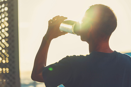 Man drinking from a reusable drink bottle