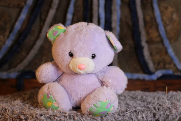 istock Purple teddy bear with cool bow tie 1385795243
