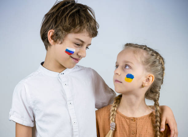 Russian Boy & Ukrainian Girl Friendship - Conceptual Symbol against War Conceptual Symbol of the Aggression of Russian President Putin Against Ukraine. Russia Invaded Ukraine on February 24, 2022. ukrainian language stock pictures, royalty-free photos & images