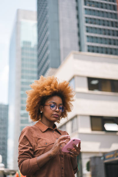 istock Afro woman using smartphone in the city 1385795711