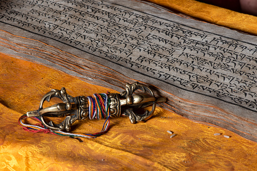 Typical items from a Tibetan Buddhist monastery:  a thunderbolt (Vajra or Dorje) and an old prayer book and prayer beads. Vajra is a Sanskrit word meaning both thunderbolt and diamond.