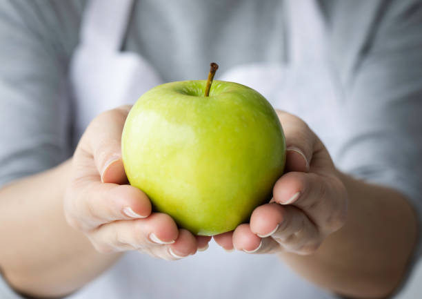 istock Woman Showing Green Apple 1385800647
