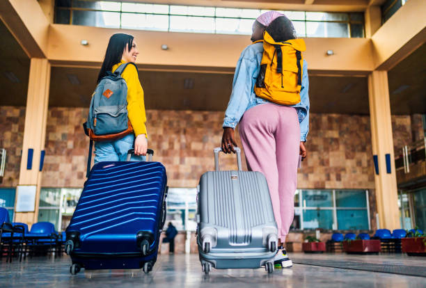 istock Girlfriends with suitcases at train station 1385800913