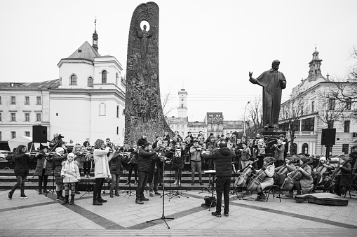 Lviv, Ukraine - March 16, 2022: INSO-Lviv Symphony Orchestra of Lviv National Philharmonic Society performed on Svobody Avenue in Lviv as part of the Free Sky art campaign in support of the call to the West and other countries to close the sky over Ukraine.