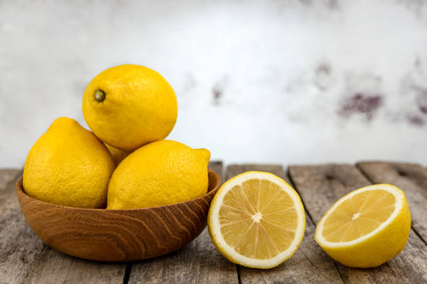 istock Fresh ripe lemons on wooden bowl 1385808741