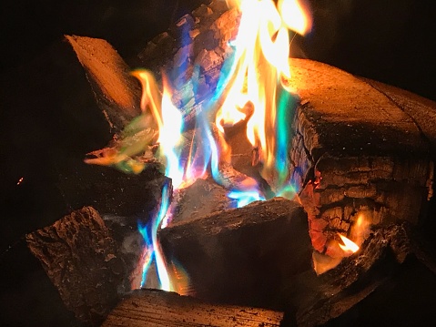 Wood burning on a firepit.  Colourful flames including blues from using firedust.