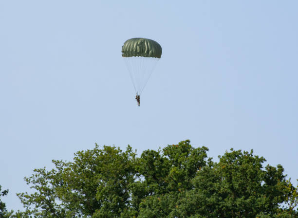 WW2 Soldier Jumping from plane with parachute WW2 Soldier jumps from C-47 Vintage aircraft plane during a world war re-enactment and display in  Kent, United Kingdom.

1st July 2018 operation market garden stock pictures, royalty-free photos & images