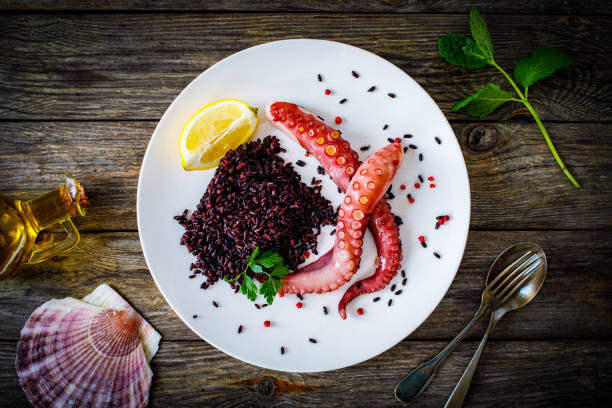 Boiled octopus and vegetables on wooden table