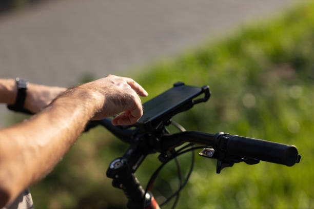 istock Man planning route using GPS navigation application in mobile phone on his bicycle bike. 1385846876