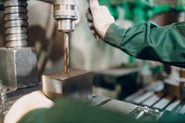istock Worker with drilling boring machine works on metal factory 1385847253
