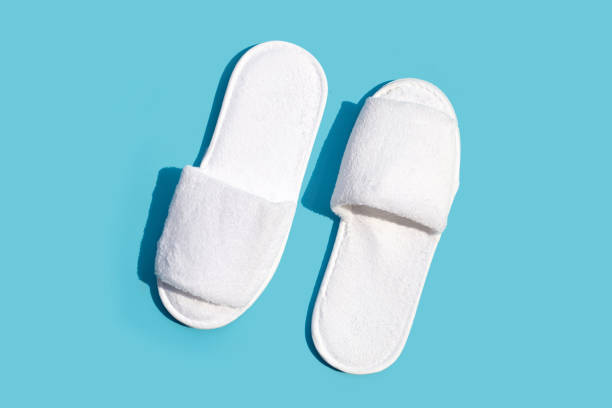 istock Hotel slippers on blue background. Copy space 1385848732
