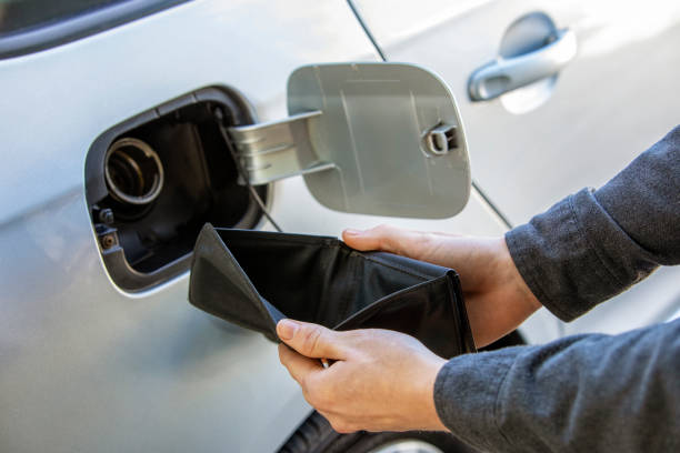 Empty Wallet Showing Gas Prices Increasing at the Pump Station A man holding open an empty wallet at the gas at the station showing inflation and economic impact at the gas pump. rigging stock pictures, royalty-free photos & images