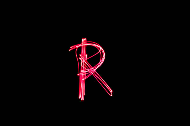 istock Letter R written with light paint photography technique on black background. 1385858055