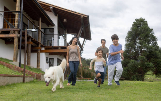 Happy family playing outdoors with their dog Happy Brazilian family playing outdoors with their dog in the garden and smiling - lifestyle concepts dog retrieving running playing stock pictures, royalty-free photos & images